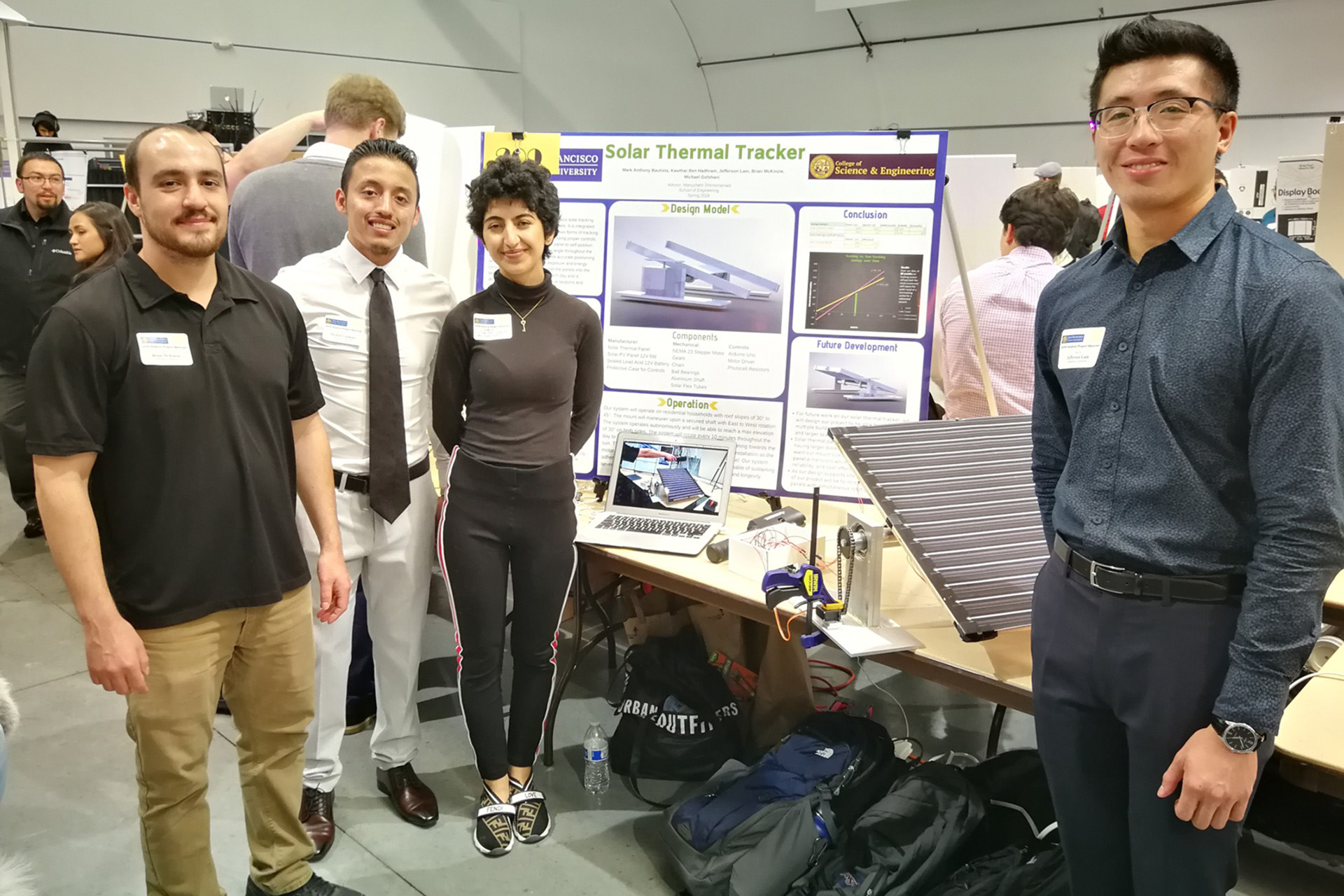 engineering students in front of a science fair display