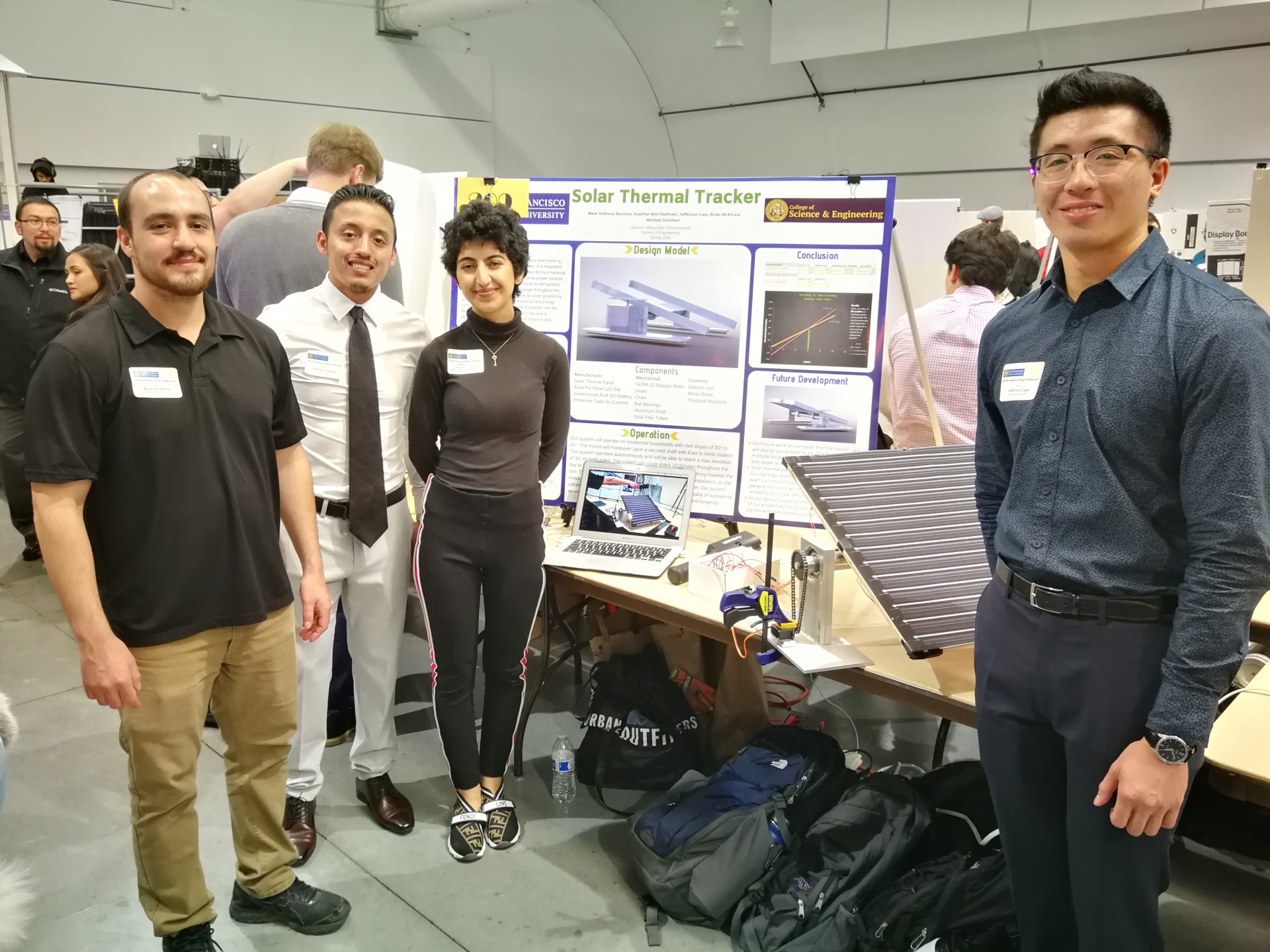 engineering students in front of a science fair display